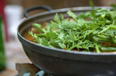 Close-up of food garnish with coriander in metal container
