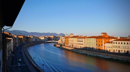 Panoramic view of river amidst buildings against clear blue sky