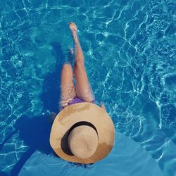 Low section of woman relaxing in swimming pool