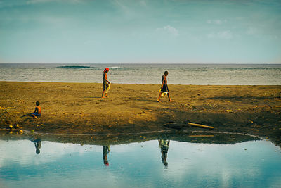 People on beach against sky