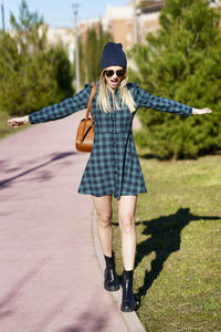 Full length portrait of woman standing in sunglasses