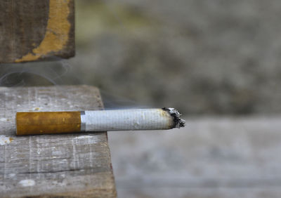 Close-up of cigarette smoking on wood