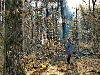 Man standing by trees in forest during autumn