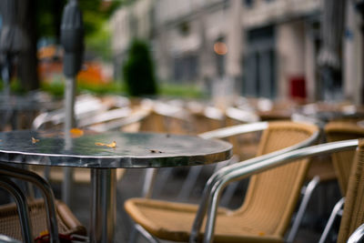 Close-up of chairs on table in city