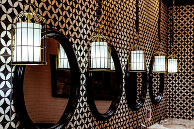 Low angle view of illuminated lamp hanging on wall