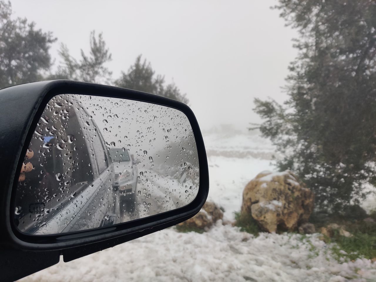 REFLECTION OF SIDE-VIEW MIRROR OF CAR ON WINDSHIELD