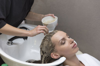 Portrait of woman holding camera in bathroom