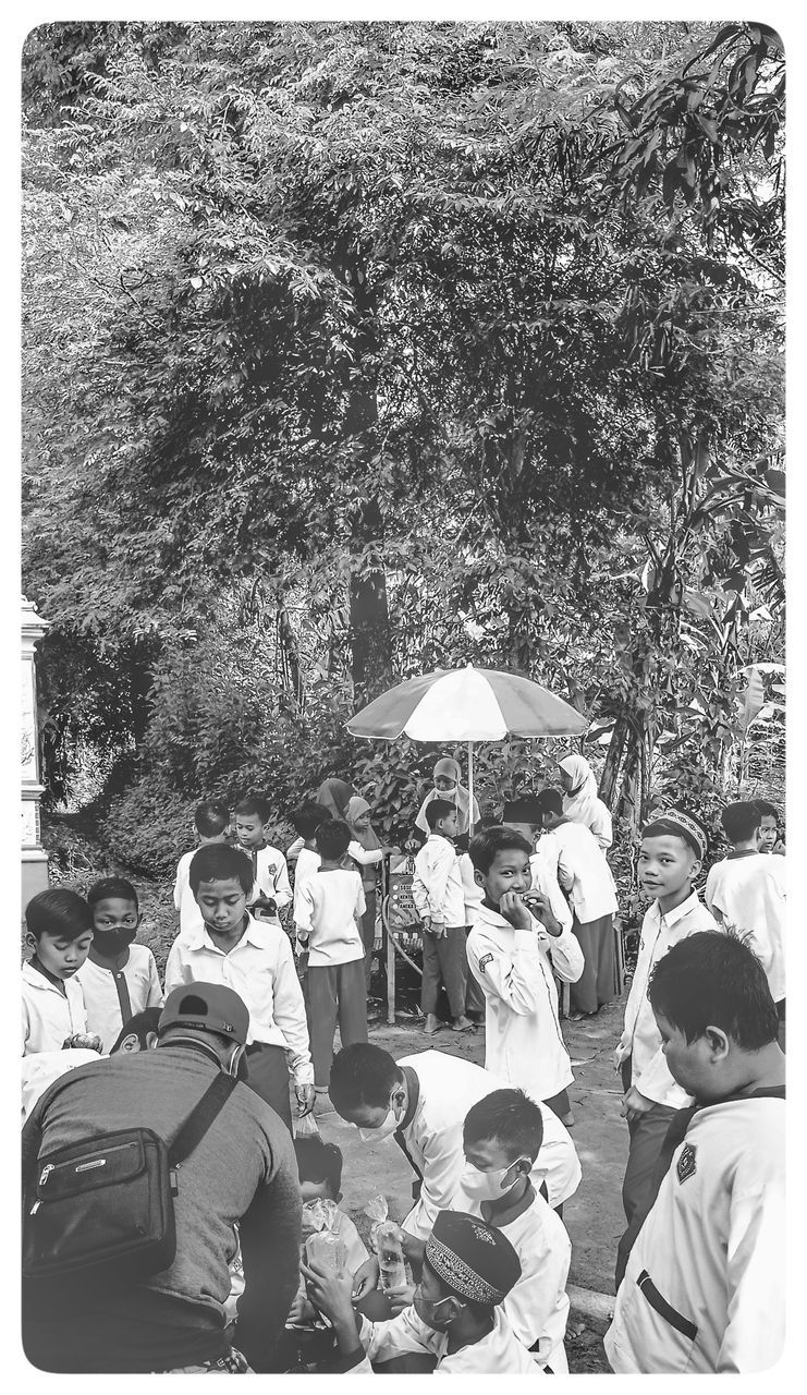 group of people, men, umbrella, black and white, adult, tree, transfer print, auto post production filter, nature, women, protection, day, medium group of people, plant, sitting, outdoors, group, lifestyles, person, monochrome photography, crowd, clothing, togetherness, leisure activity, architecture