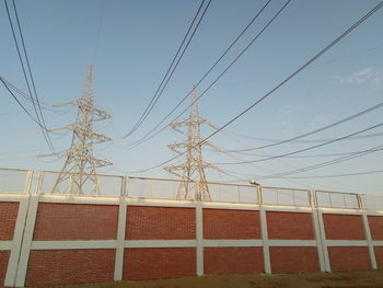 Low angle view of electricity pylon against sky
