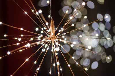 Low angle view of illuminated lighting equipment against sky