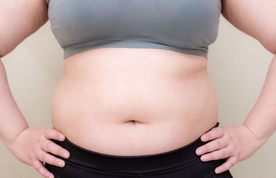 Midsection of woman standing against white background