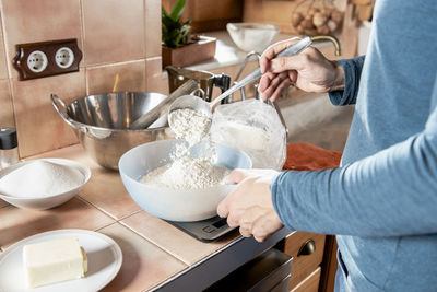 Close up of middle aged man hands mixing flour and other ingredients