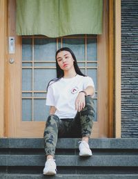 Portrait of young woman sitting on staircase