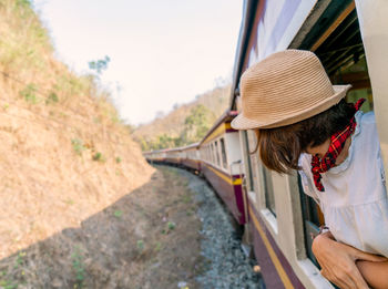 Rear view of woman on railroad track amidst plants