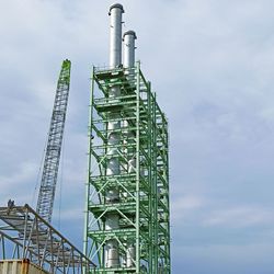 Low angle view of crane against sky