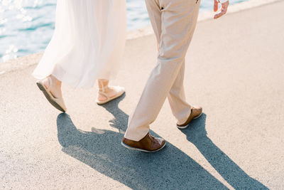 Low section of woman walking on road