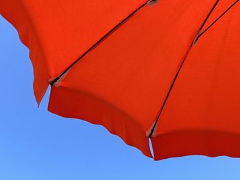 Low angle view of red umbrella against clear sky