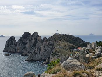 Rock formations by sea against sky