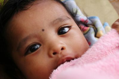 Portrait of cute baby girl on bed