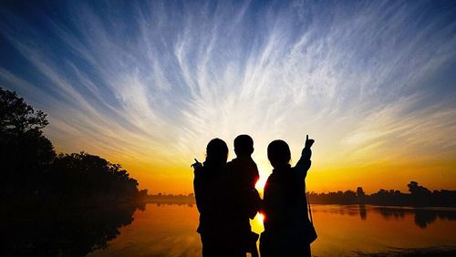 Silhouette of woman in lake at sunset