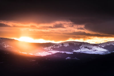 Scenic view of snowcapped mountains against sky during sunset