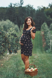 Portrait of smiling young woman standing on field