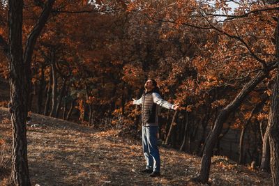 Man standing by trees in forest during autumn