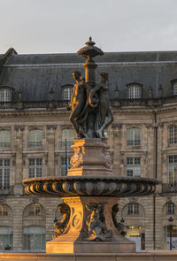 Statue against historic building in city