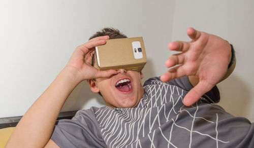 Happy boy watching in smart phone through cardboard virtual reality simulator
