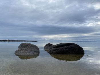 Rocks on sea shore against sky