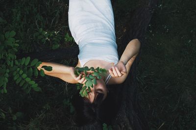 Midsection of woman holding flower on field