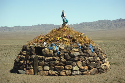 People standing on rock by land against sky