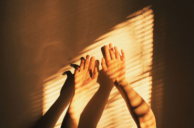 Close-up of hands against wall at home