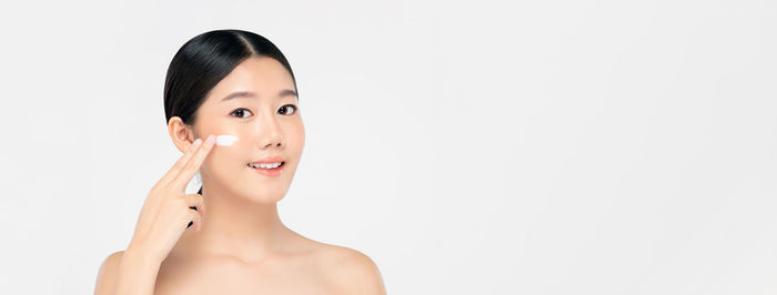 Portrait of young woman against white background