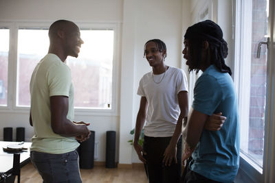 Smiling coach talking to teenage students in games room