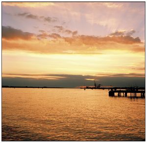 Scenic view of sea against dramatic sky during sunset