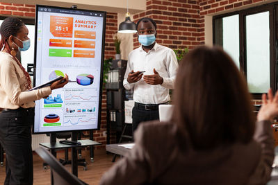 Businessman wearing mask giving presentation