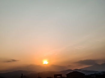 Scenic view of silhouette mountains against romantic sky at sunset