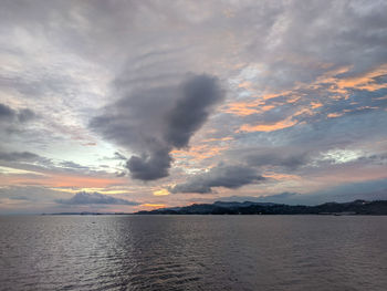 Scenic view of sea against dramatic sky during sunset