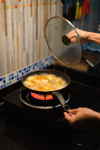 Close-up of woman preparing food on stove