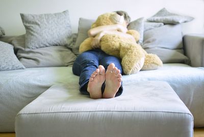 Full length of baby lying on sofa at home