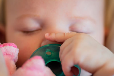 Close-up of baby girl sleeping with pacifier
