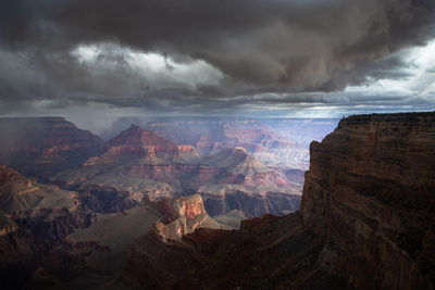 Scenic view of mountain range against cloudy sky