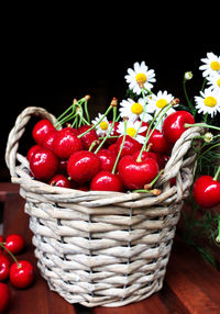 Fruit basket with ripe cherries and flowers on a dark background. organic, fresh berries