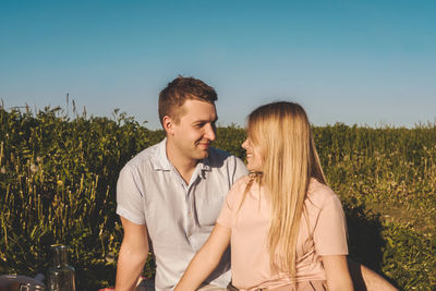 Young couple kissing against sky