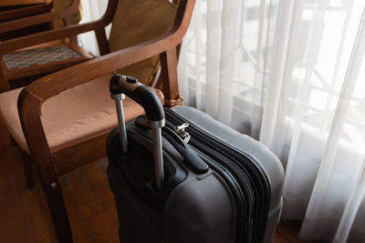 High angle view of luggage by empty chair at home