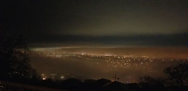 Illuminated city against sky at night