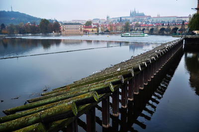 Bridge over river in city against sky