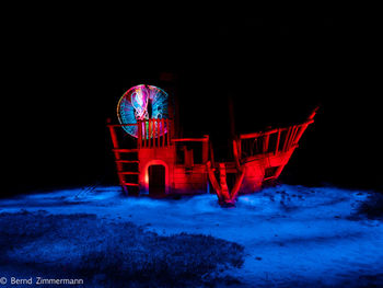 Illuminated ferris wheel during winter at night
