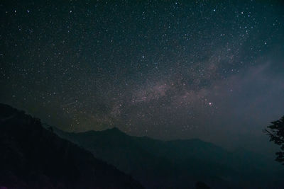 Scenic view of mountains against star field at night